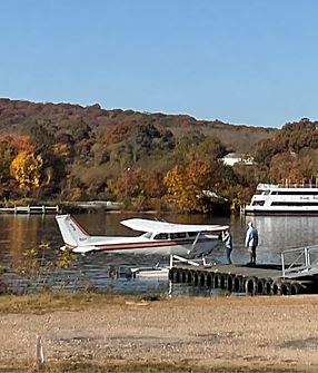 Fall colors a boat named Lady Katherine seaplane students on the dock ready for an intro flight